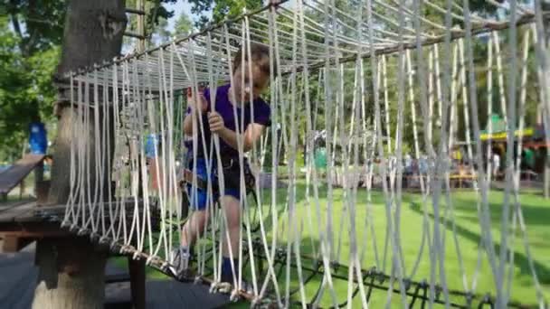 Jongen op touw parcours in pretpark — Stockvideo