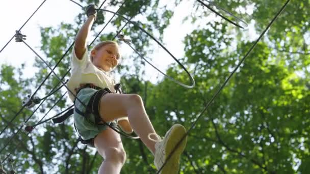 Bottom view meisje klimmen touw parcours in pretpark — Stockvideo