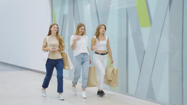 Amigos felices caminando en el centro comercial después de ir de compras — Vídeos de Stock