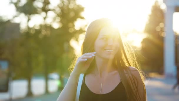幸せな女性は日没時に通りを歩く — ストック動画