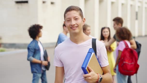 Alegre estudante do sexo masculino posando perto da faculdade — Vídeo de Stock