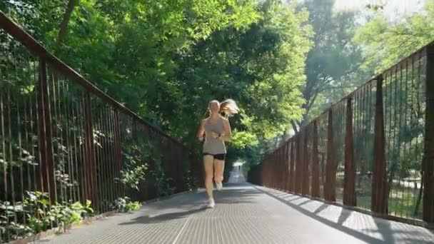 Güneşli bir günde köprüde koşan bir kadın — Stok video
