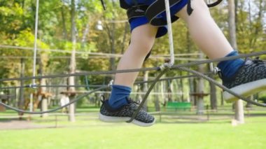 Küçük çocuk lunaparkta ip yolculuğunun tadını çıkarıyor.