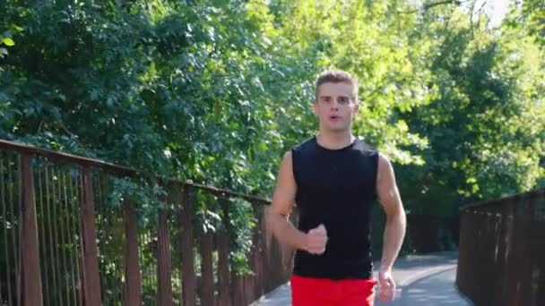 Zpomalený běžec na mostě v parku — Stock video