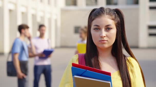 นักเรียนหญิงโพสท่าใกล้อาคารวิทยาลัย — วีดีโอสต็อก