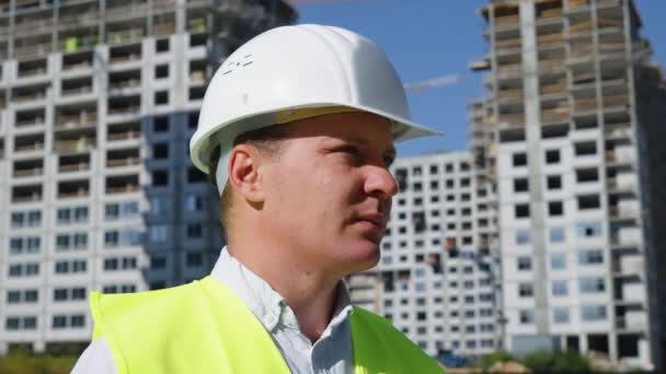 Retrato de empreiteiro de construção em pé no local de construção — Vídeo de Stock
