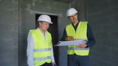 İnşaat alanındaki insanlar planları tartışıyor