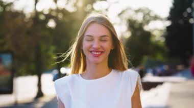 Caddede kameraya gülümseyen mutlu kadın