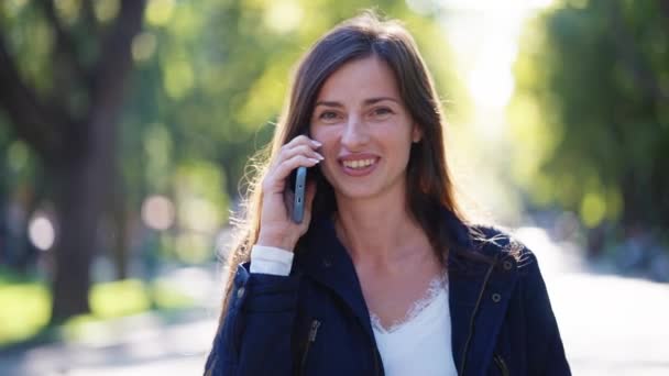 Vrouw barsten in lachen terwijl praten over de telefoon — Stockvideo