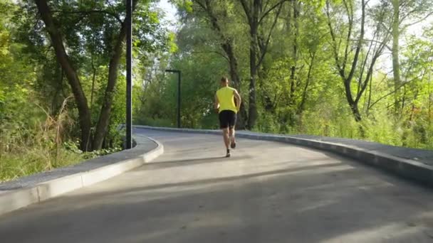 Mann läuft in Zeitlupe auf Kreisstraße — Stockvideo