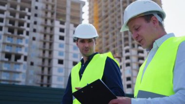 İnşaat alanının planlarını mimar ve müfettiş kontrol ediyor
