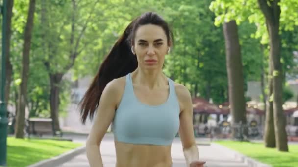 Vrouw joggen met oortjes in de ochtend — Stockvideo
