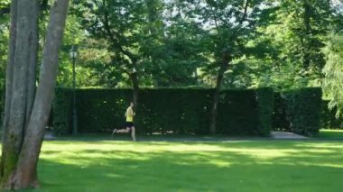 Yeşil parkta koşan formda bir adam.