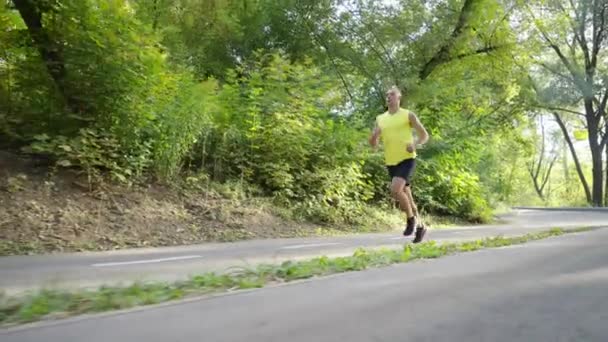 スローモーションで道路を走るスポーツマン — ストック動画