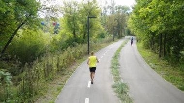 Ağaçlar arasında yolda koşan insanlar