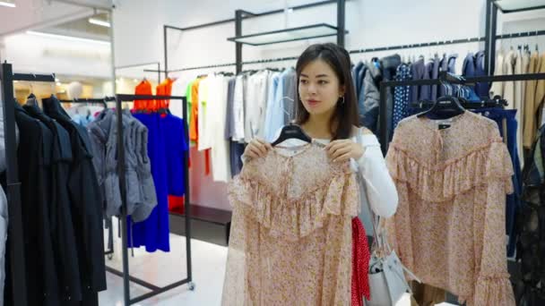 Asiatico donna cercando su camicetta a moda negozio — Video Stock