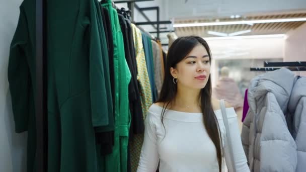 Donna asiatica guardando i vestiti al negozio di moda — Video Stock