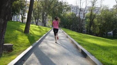 Kadın koşucu sabah parkta egzersiz yapıyor.