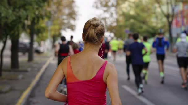 Vrouw loopt marathon in de stad straten — Stockvideo