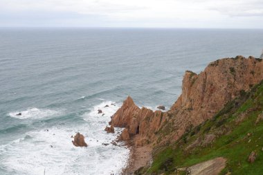 Kayalıkların dikey görüntüsü ve arka planda okyanus var.