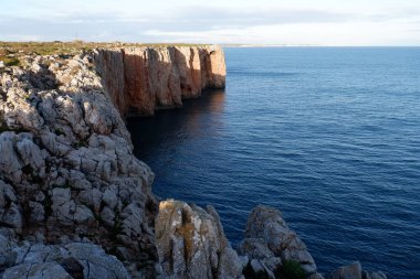 Deniz ve mavi gökyüzü olan bir uçurum manzarası
