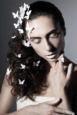 Beyaz kelebek olan güzel bir genç kadın portresi.