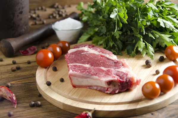 Beef steak on a wooden board on a wooden background — Stock Photo, Image