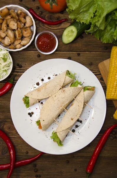 Burrito på tallrik med grönsaker och peppar ovanifrån — Stockfoto