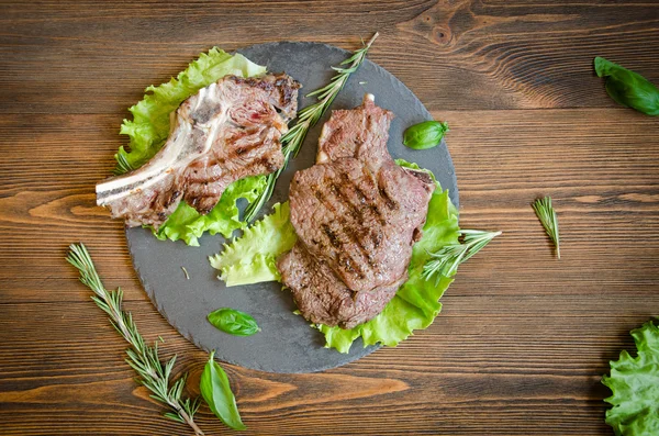 Grilled steak black plate top view — Stock Photo, Image