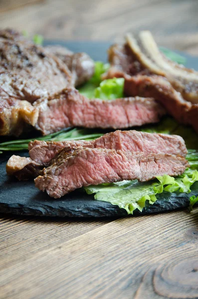 Gegrilltes Steak schwarzer Teller Holztisch — Stockfoto