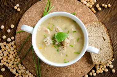 Beyaz tabak bezelye çorbası yuvarlak kurulu flatlay