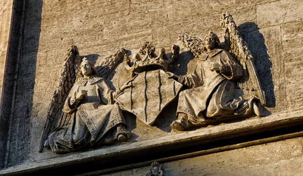 Dos ángeles mantienen una escultura de corona en fachada en Valencia, España —  Fotos de Stock