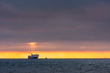 Günbatımı, ufuktaki gemi.