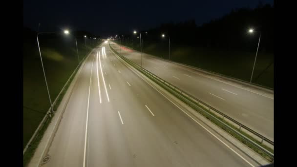 Świateł samochodów schodzili autostrady w nocy. Czas okrążeń. — Wideo stockowe