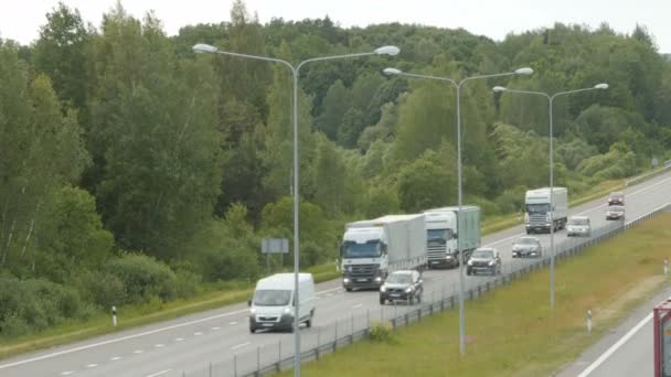 Muchos camiones y coches se mueven por carretera — Vídeo de stock