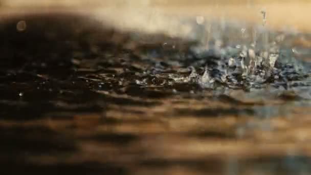 Close-up van het water druipende, in het zonlicht. — Stockvideo
