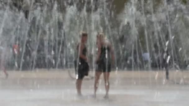 Girls running through the fountain — Stock Video