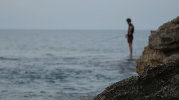 Pescador ao entardecer. silhueta de um pescador com uma vara de pesca . — Vídeo de Stock