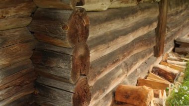Eski bir ahşap kulübenin köşesine yakın çekim. Kütükler eskimiş ve görünürde tahıl desenleri ve düğümleriyle pürüzlü bir dokusu var..