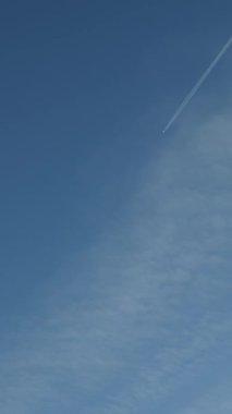 Gökyüzünde bir jet çizgisi var. Dikey video