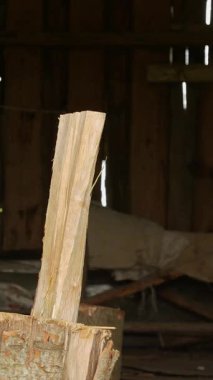 Kırsal ahşap barakanın içinde eski baltayla odun kırılıyor.