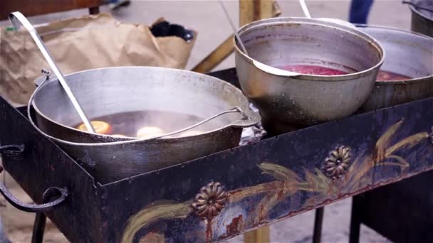 Ciotole con deliziosi vin brulè che cucinano sul carbone, venditori ambulanti che fanno cibo — Video Stock