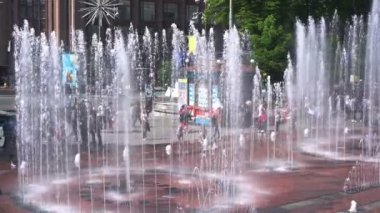 Kalabalık şehir sıcak bir yaz günü, hafta sonu zevk insanlar üzerinde çeşmeler ile kare