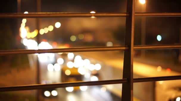 Ночной вид светофоров на оживленной дороге, дефокусированные желтые точки, двигающиеся медленно — стоковое видео