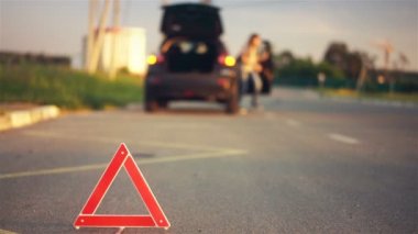 Genç kadın yolda lastiğim patladı, kırmızı uyarı üçgeni üzerinde sinirli hissediyor
