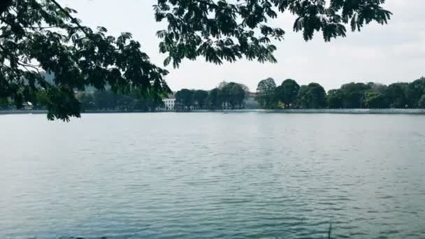 Lindo lago largo em um dia ventoso ensolarado, ondulações e luz brilhante na água — Vídeo de Stock