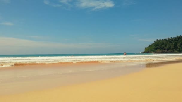 Giornata tempestosa sulla spiaggia tropicale, pochi nuotatori che camminano in acqua. Vacanze, turismo — Video Stock