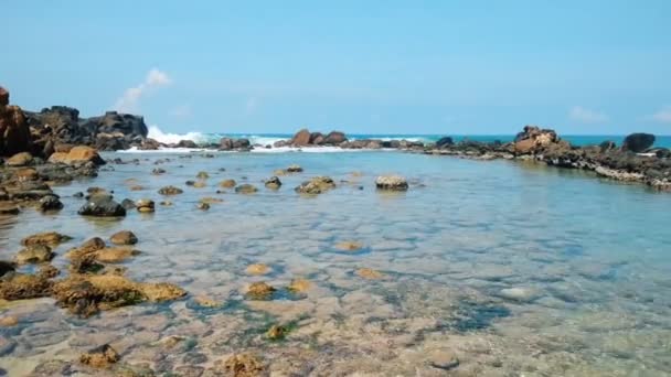 Ruhiges flaches Wasser mit Korallen, Meereswellen planschen gegen felsige Barriere — Stockvideo