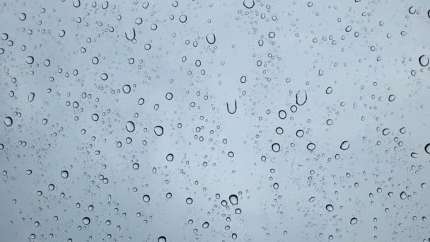 Gocce d'acqua che scorrono lungo il vetro, tempo piovoso, sfondo rilassante. Sfondi e texture — Video Stock