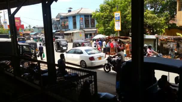 Καταπράσινες, Σρι Λάνκα - Circa Φεβρουαρίου 2016: πεζοί και κίνηση στο δρόμο. Πολυσύχναστη κυκλοφορίας κοντά στο σιδηροδρομικό σταθμό καταπράσινες, οδηγοί ταξί, ανθρώπους στο δρόμο — Αρχείο Βίντεο